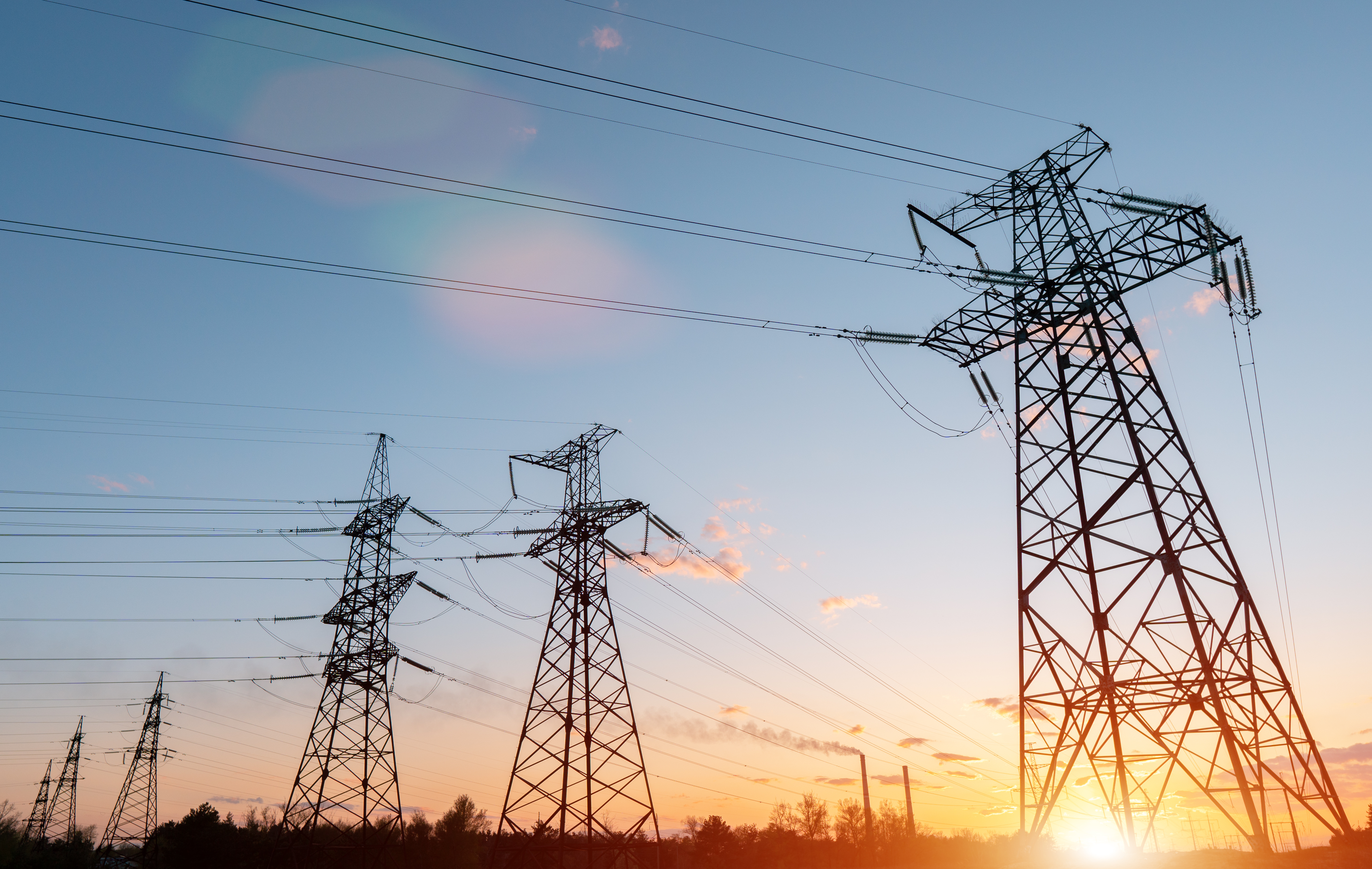 distribution electric substation with power lines and transformers, at sunset